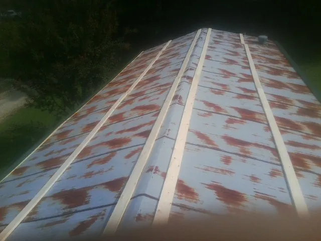 Rusted metal roof panels with new wood purlins before replacement — Storm Damage Roof Repair in Burgin by Roofing Brothers