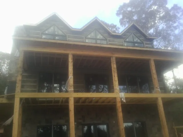 Dormers and porch framing on a large log home under construction — Roof Coating work by our crew in Burgin
