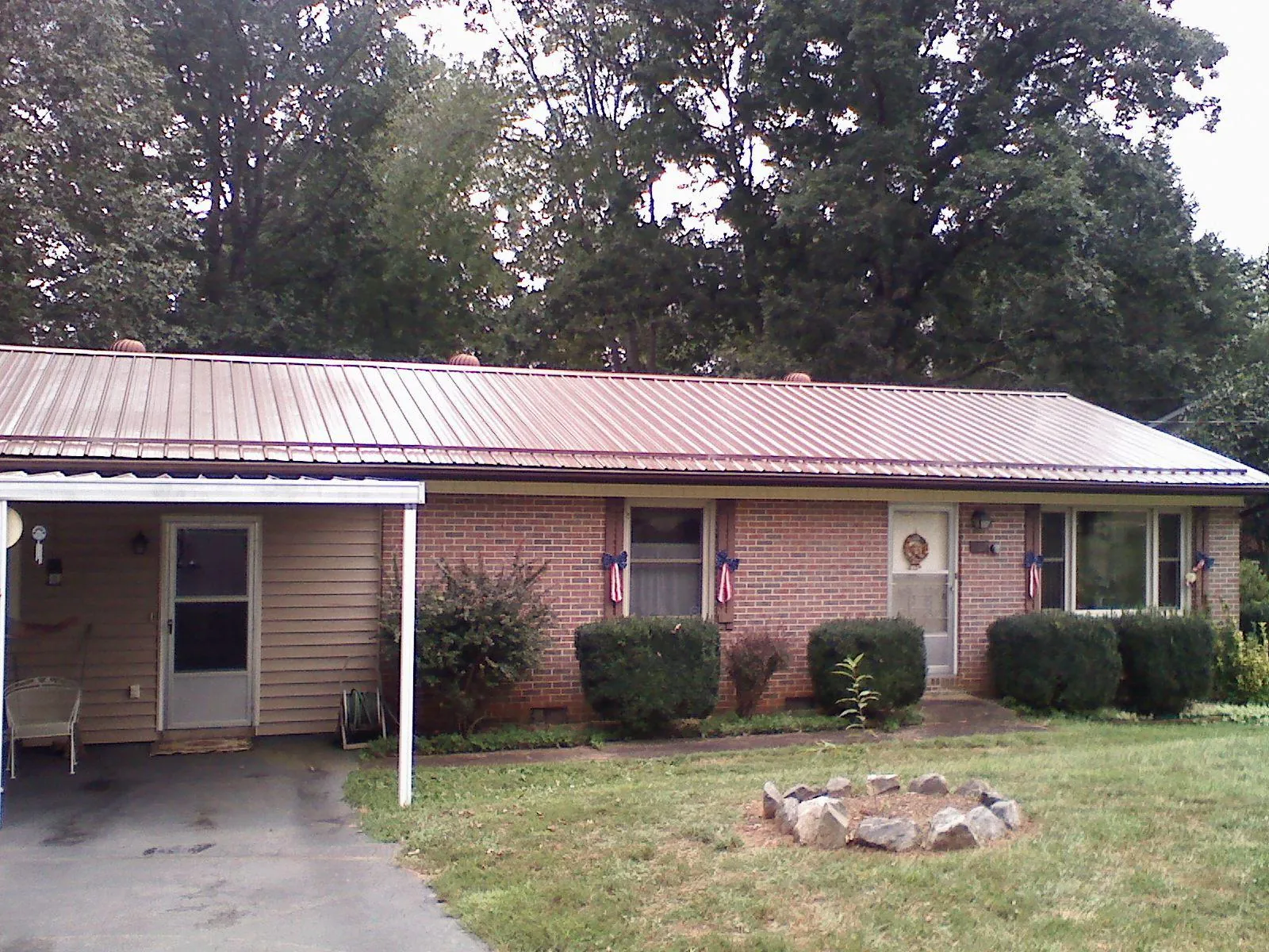 Bronze metal roof and carport on a brick ranch home — Roof Repair work by our crew in Burgin